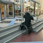 Go down a flight of stairs with handrail in a wheelchair